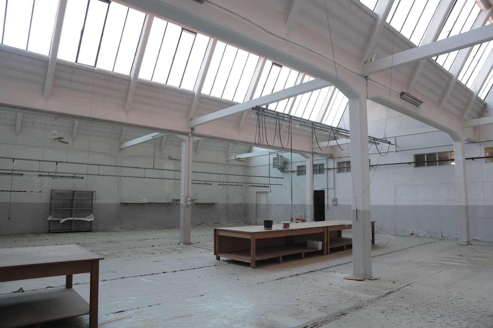 Bare plain concrete floor in a bright empty hall — the before